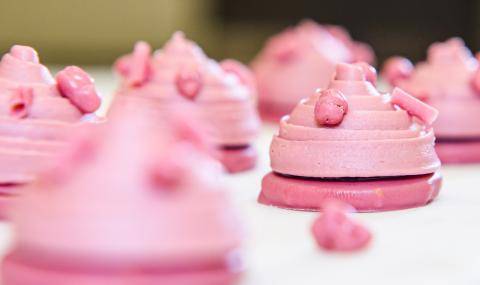A petit four made with ruby chocolate resting on a spoon on the booth display