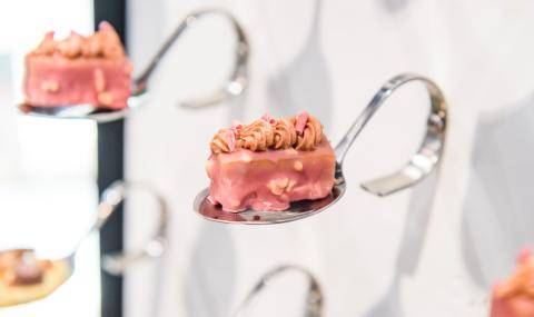 A Timut Pepper Financier coated with Ruby, topped with a blanched almond Ruby gianduja, Ruby Curls, and Ruby Biscottino