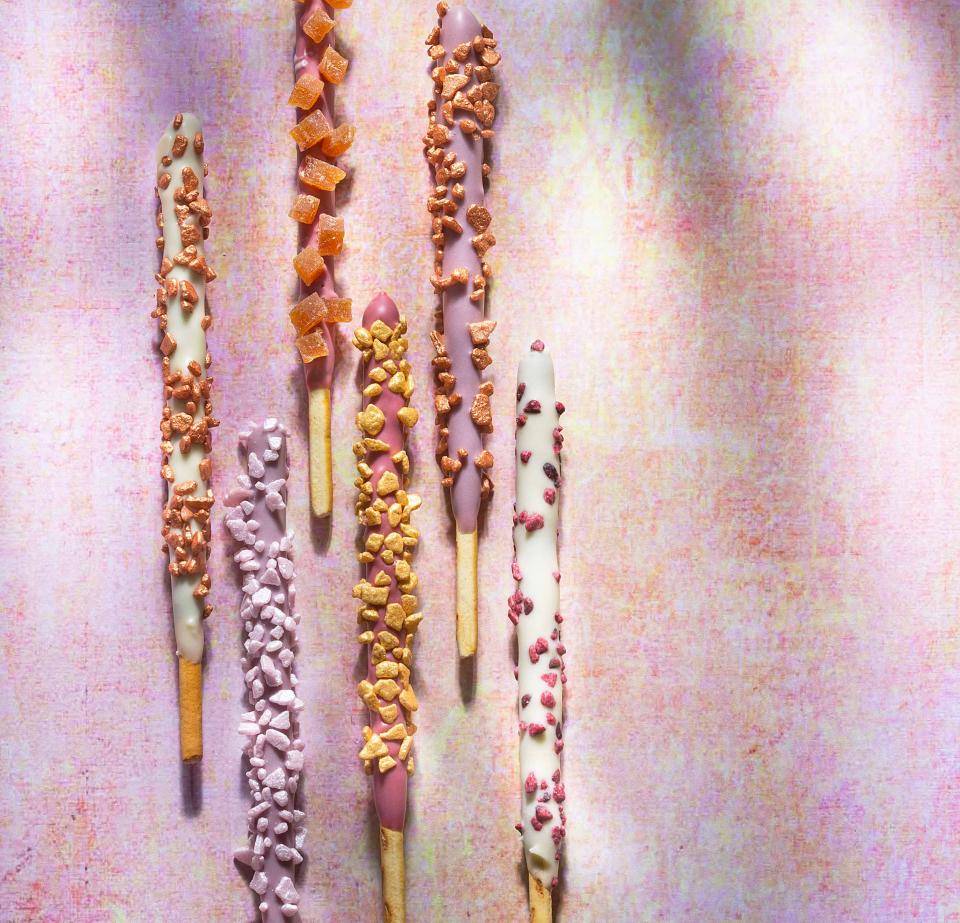 Chocolate-covered pretzel sticks with sprinkles