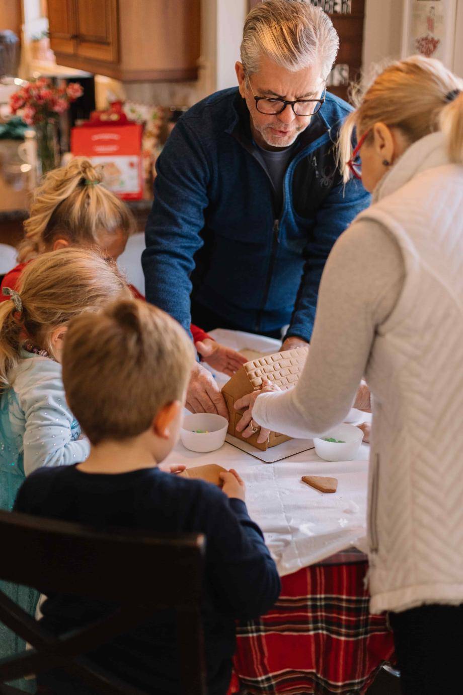 Grandparents creating gingerbread house with grandchildren. Photo by Phillip Goldsberry on Unsplash.